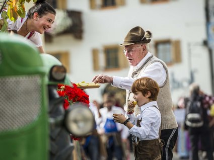 Appartamento a Naz-Sciaves Uomo anziano e bambino in abiti tradizionali mangiano mele a una festa